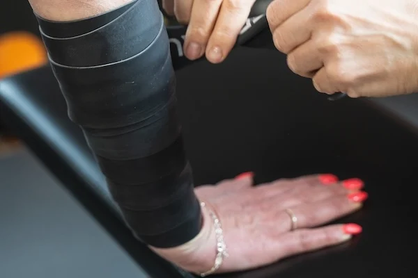 Anwendung eines Flossing-Bandes am Arm