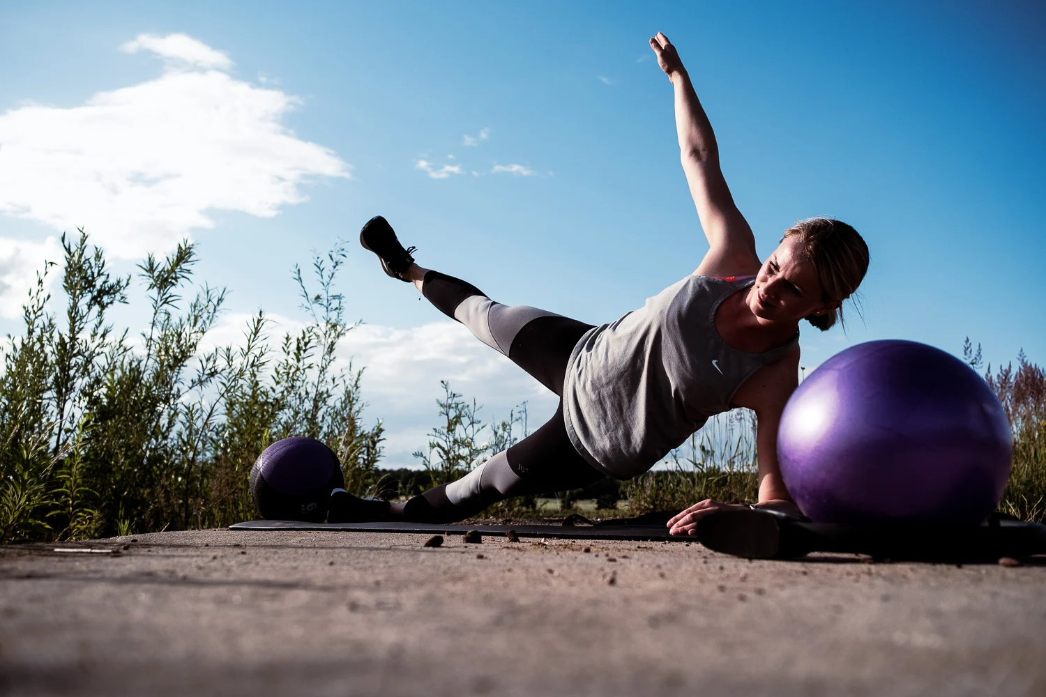 Kim beim Seitstütz im Freien neben einem Gymnastikball